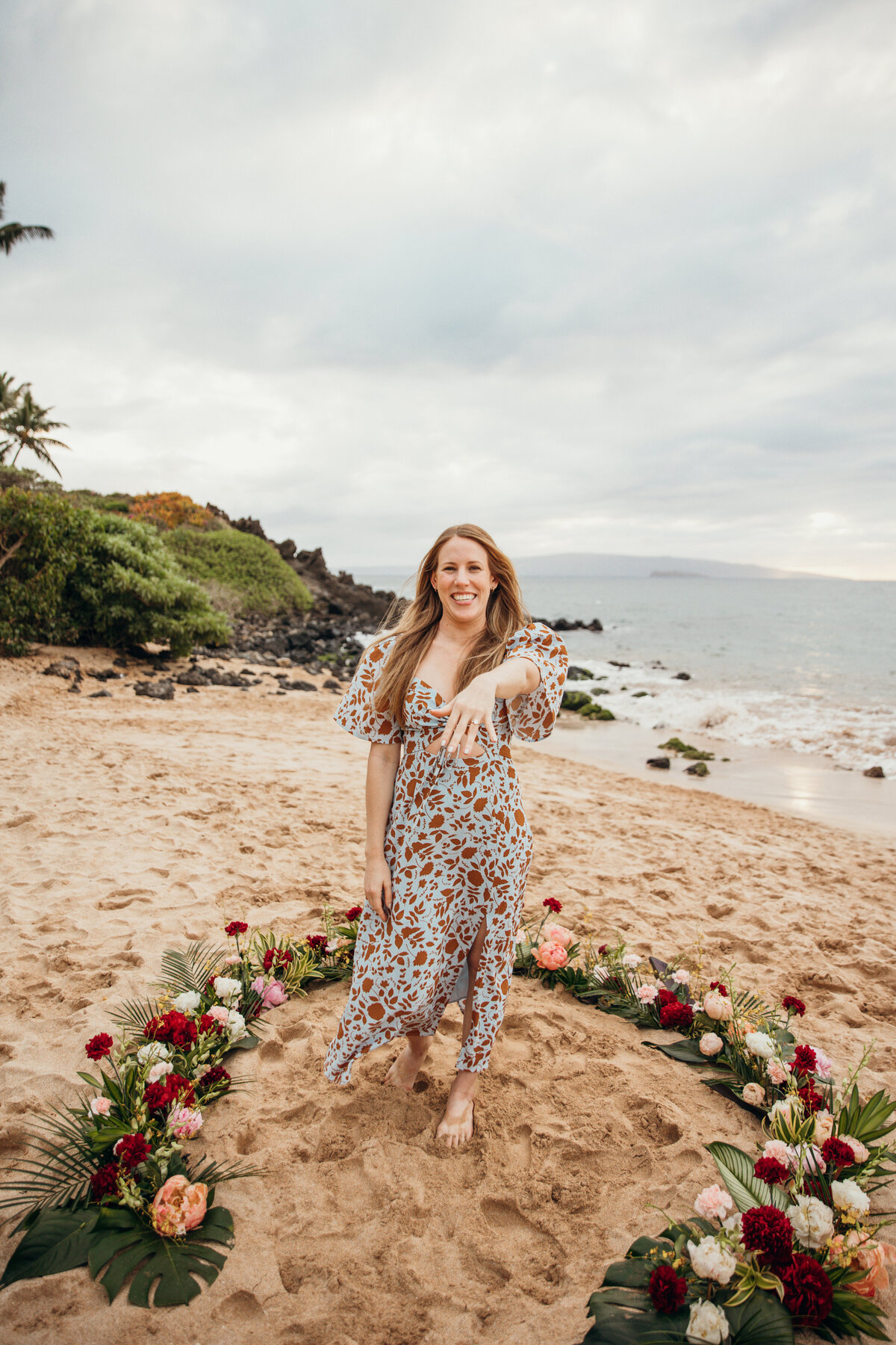 Hawaii Engagement Photographer captures woman showing off engagement ring after intimate beach proposal