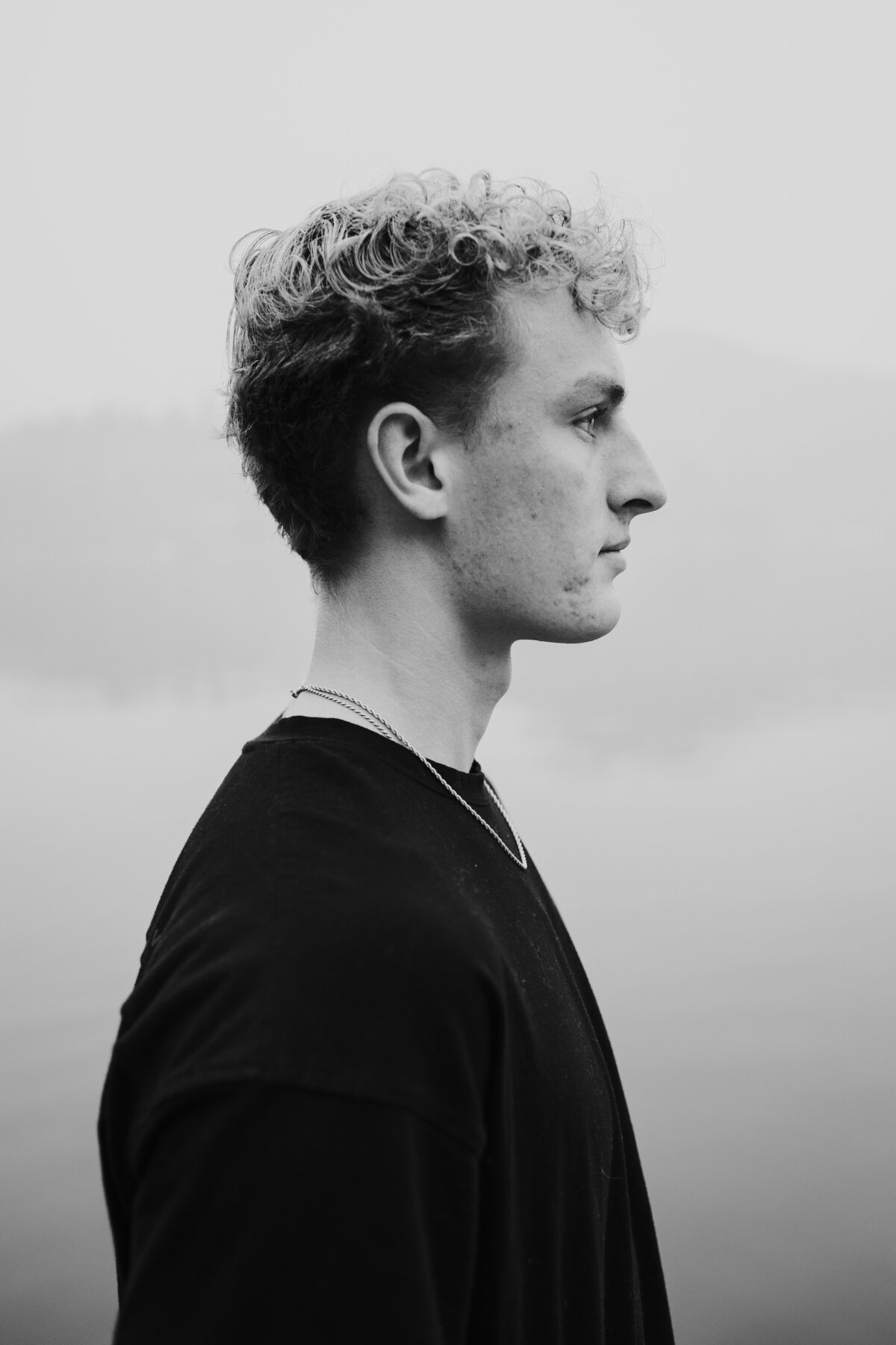 Black and white side profile of young man with smoky background.