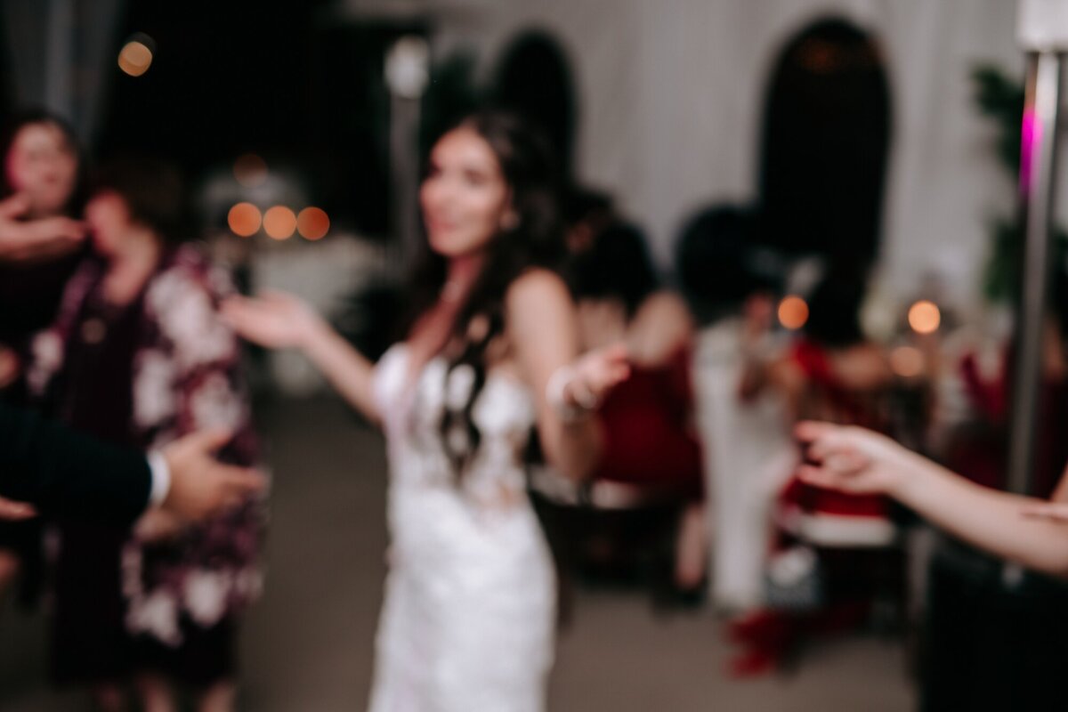Blurry fun dancing photo of the bride and some of her guests.