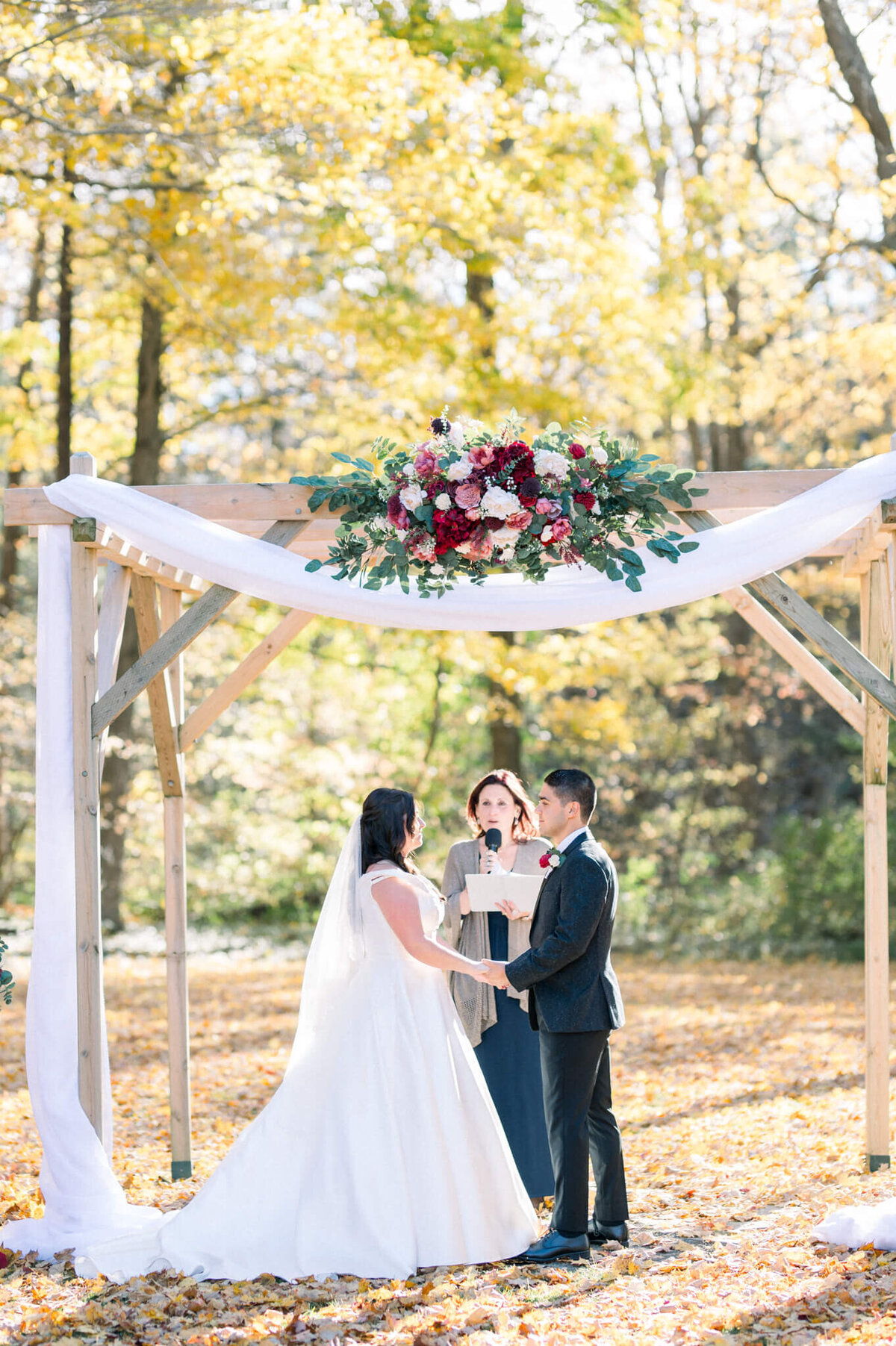 Bride and groom under the decorated arches for their Balls Falls wedding. Captured by Niagara wedding photographer