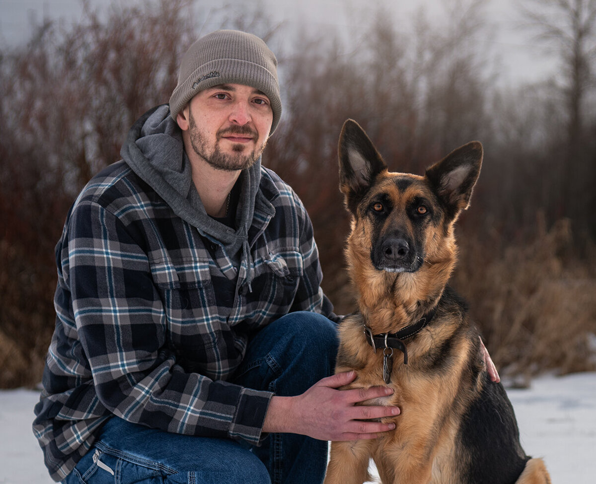Dog and owner are having their family portraits taken in the winter in duluth, minnesota