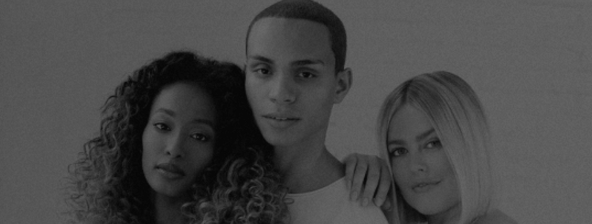 Two women and one male posing together in front of a blank wall in a studio rental space in Chicago. 