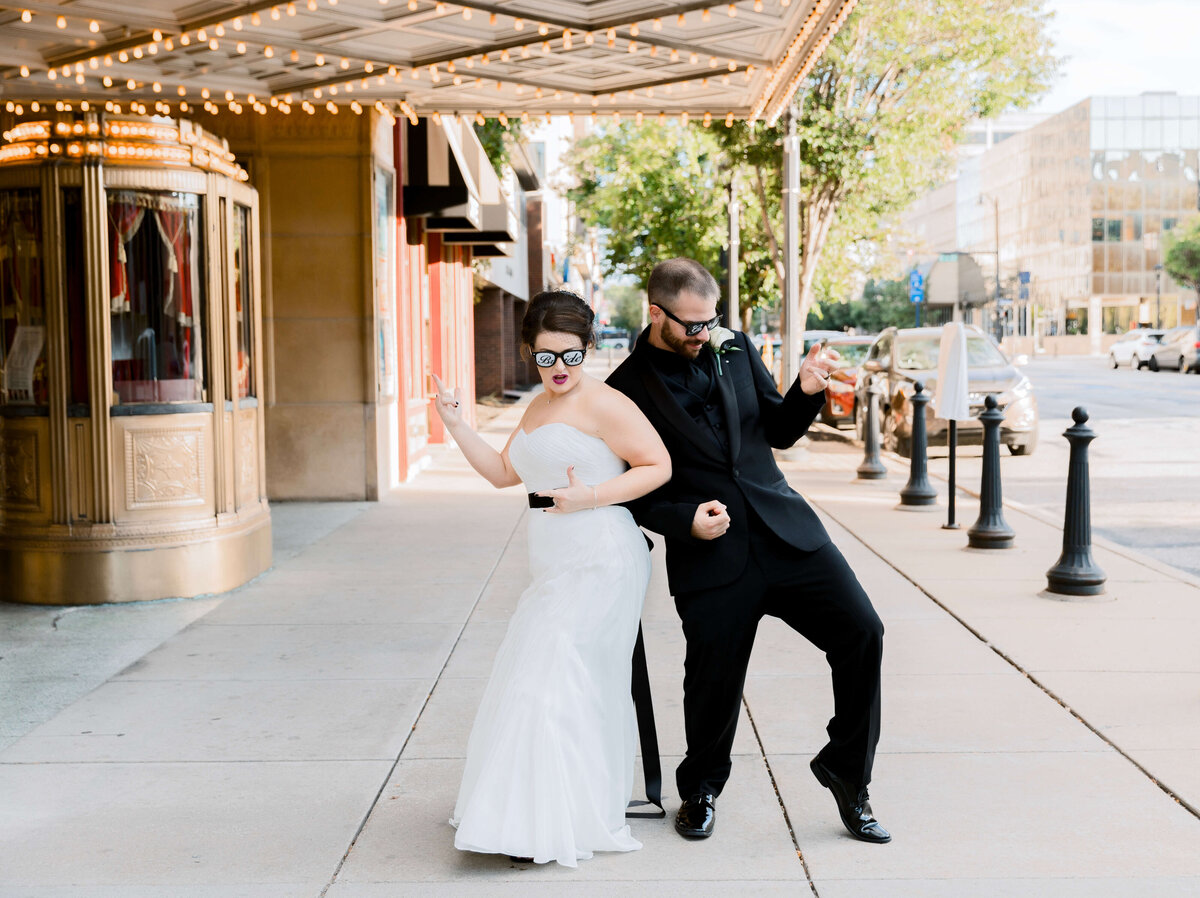 Bride and groom dancing on the sidewalk outside of the Warner Theater in Erie, Pa