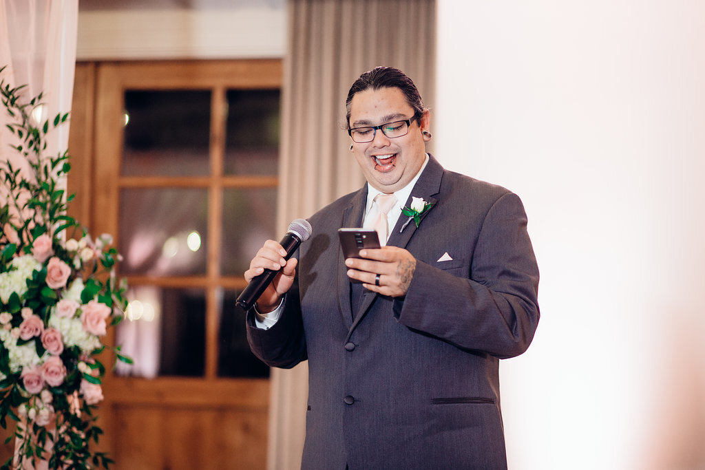 Wedding Photograph Of Man In Gray Suit Laughing While Holding a Microphone Los Angeles