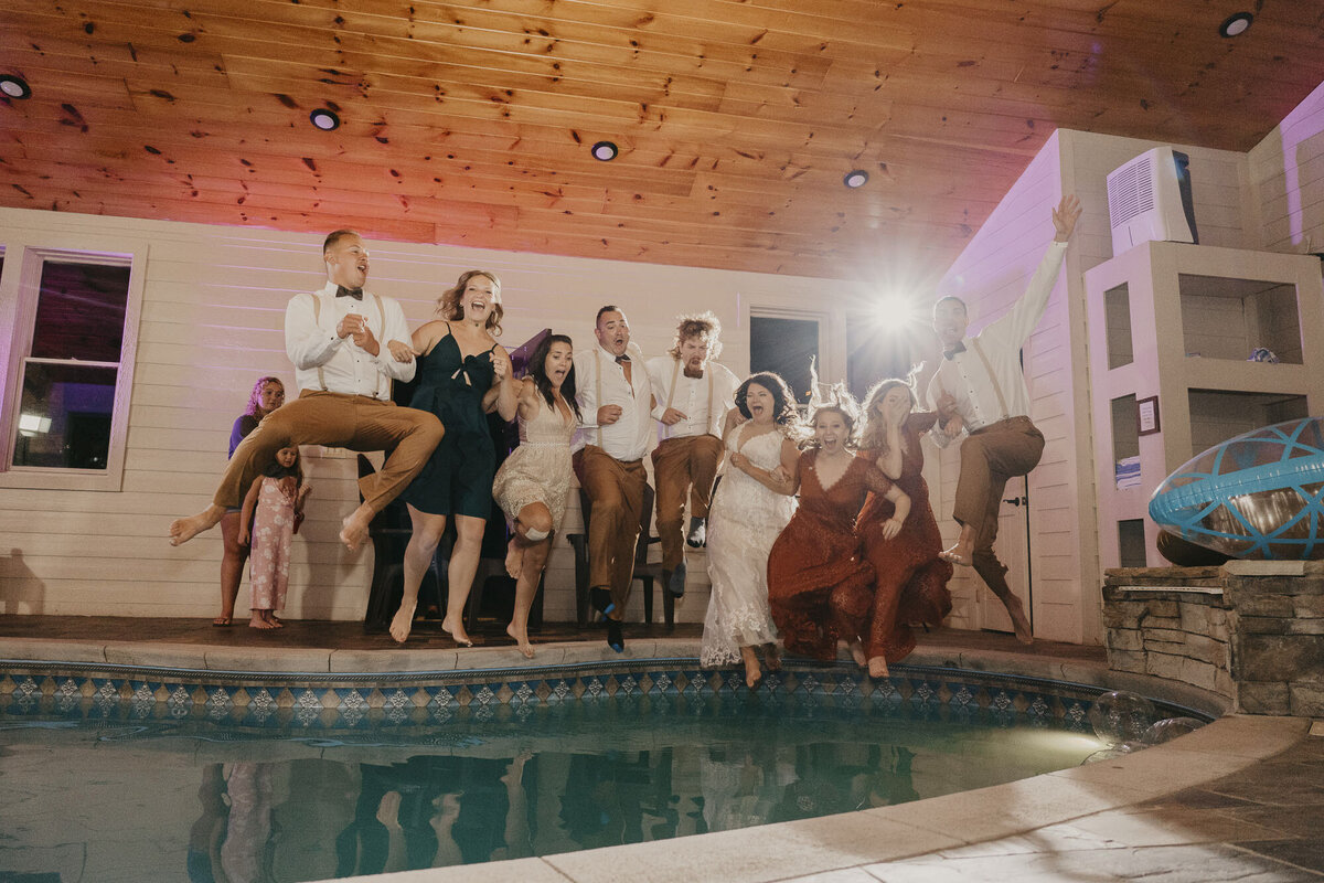 Entire wedding party jumping into a pool together
