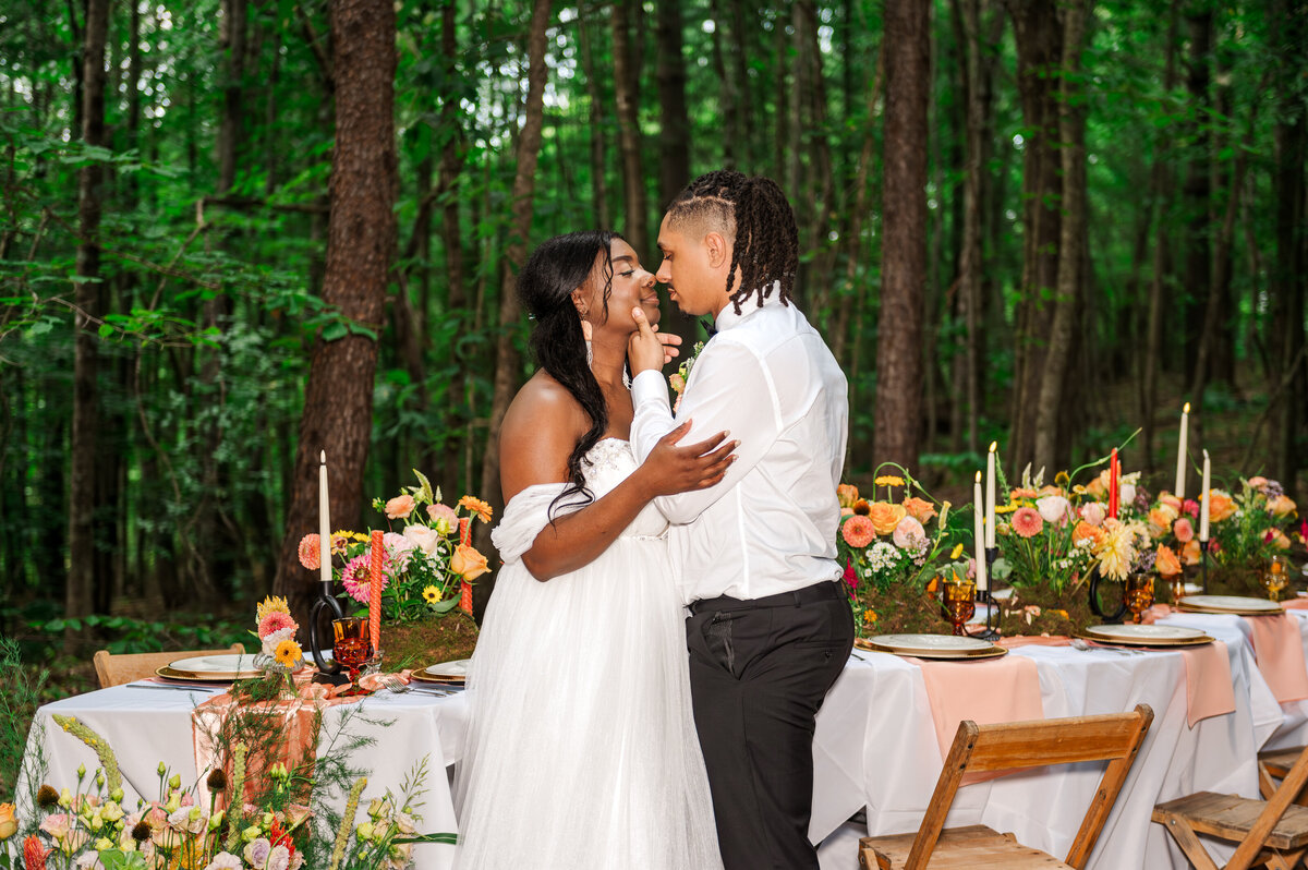 Bride and groom standing next to elaborate and vibrant tablescape in Red River Gorge