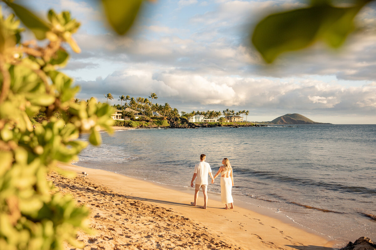 Maui Couples Photographer captures newly engaged couple walking hand in hand during beach engagement photos