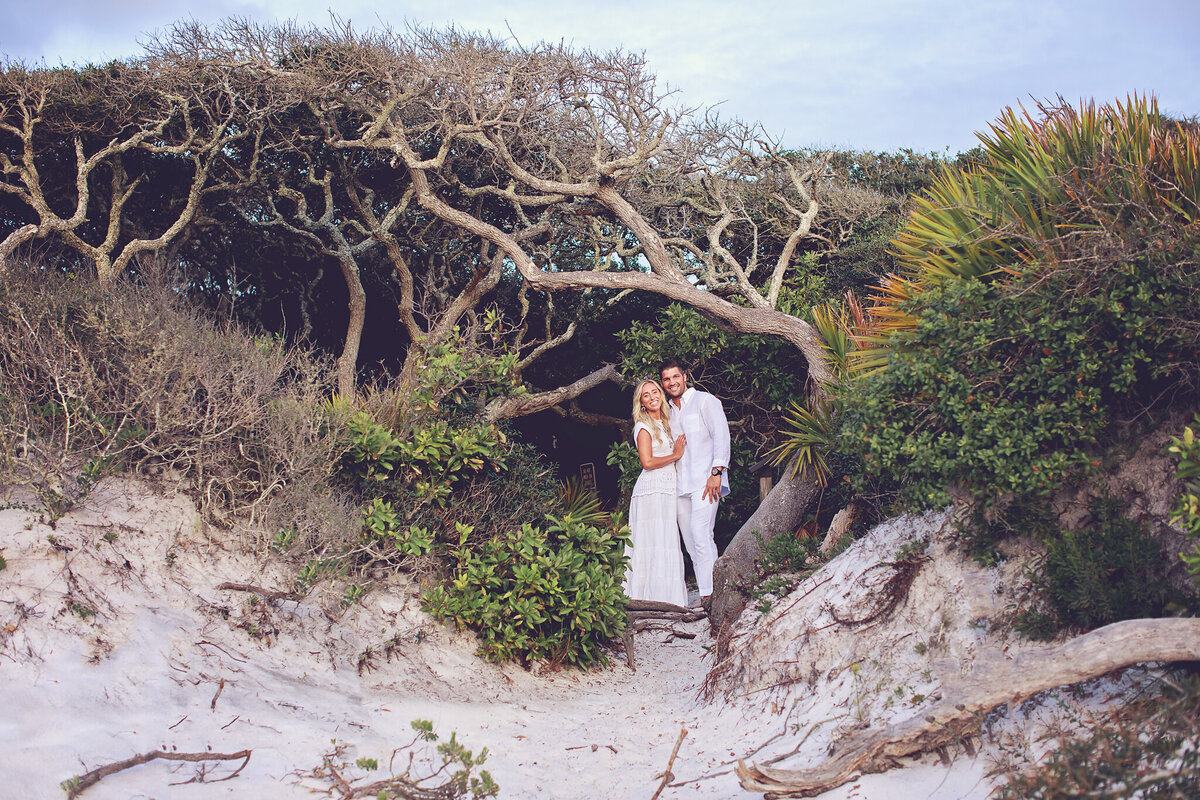 engaged couple posing in front of an entrance to the trail at Grayton State Park, Florida.