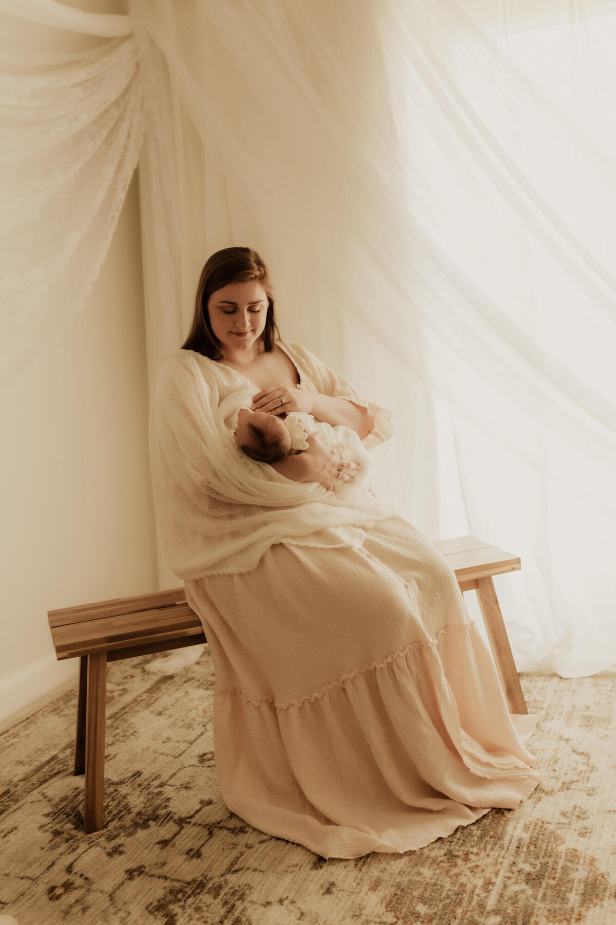 Mother breastfeeding her newborn daughter for a studio portrait in Oklahoma City