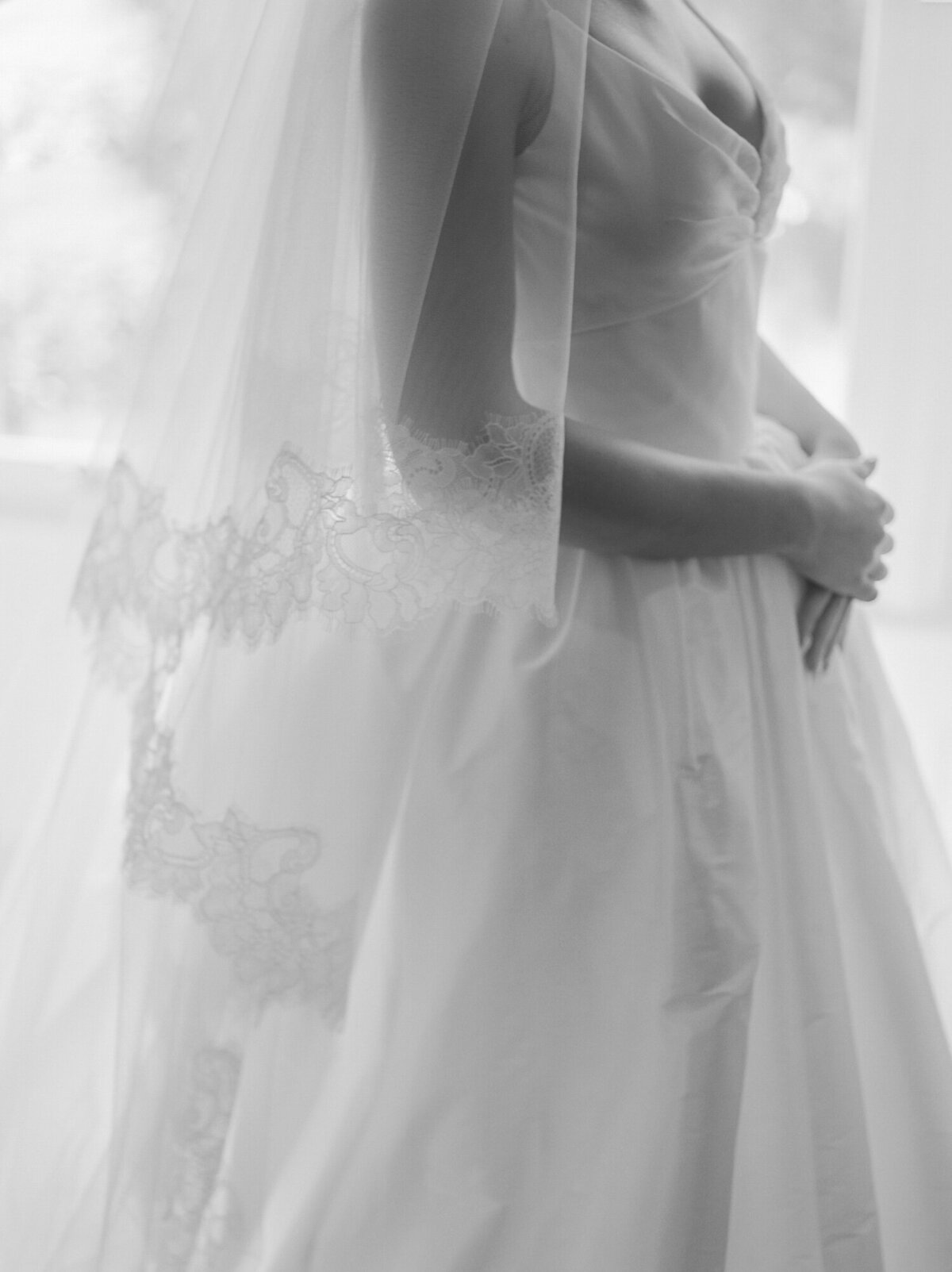 a soft black and white photo of light through cathedral veil lace
