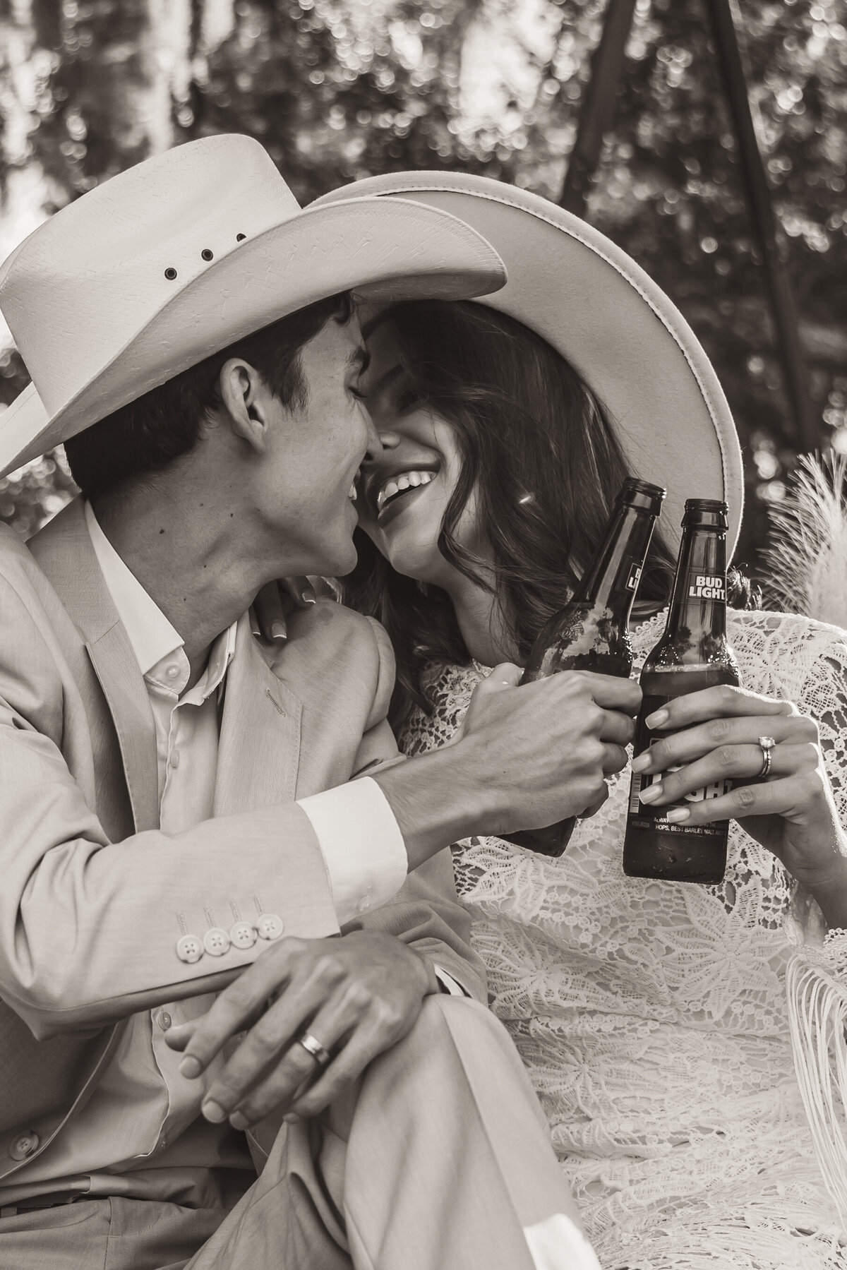 Shannon Lee, from Love Like Wild Photography, captures a joyful couple in cowboy hats sharing a toast with beers.