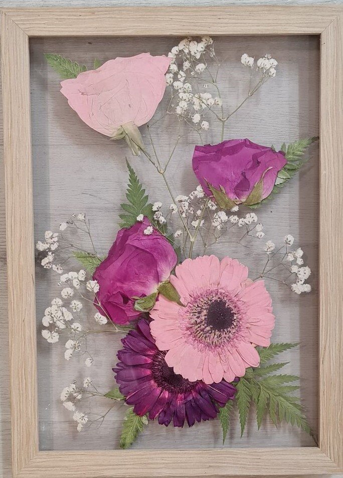 Pressed flowers in glass frame.