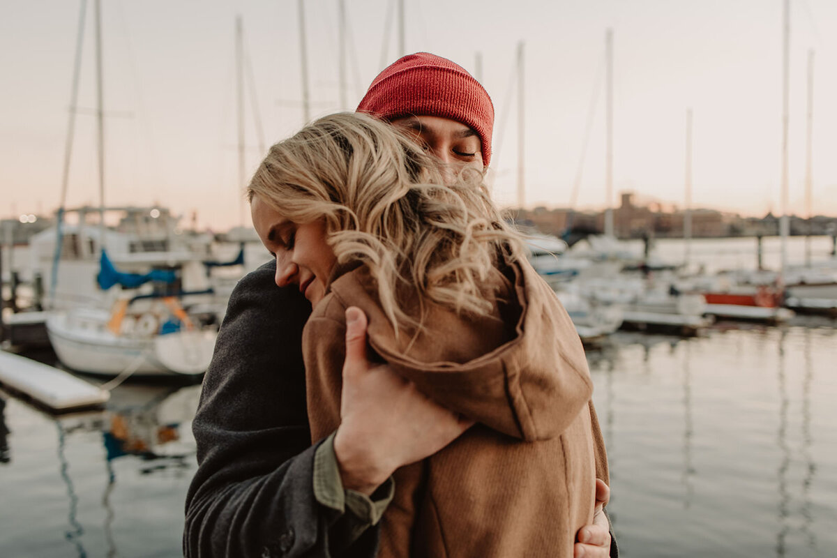 Two people hugging at a marina