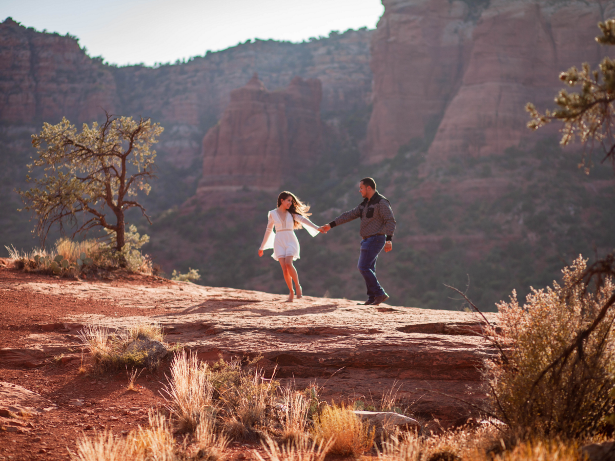 bride and groom walking across mountain