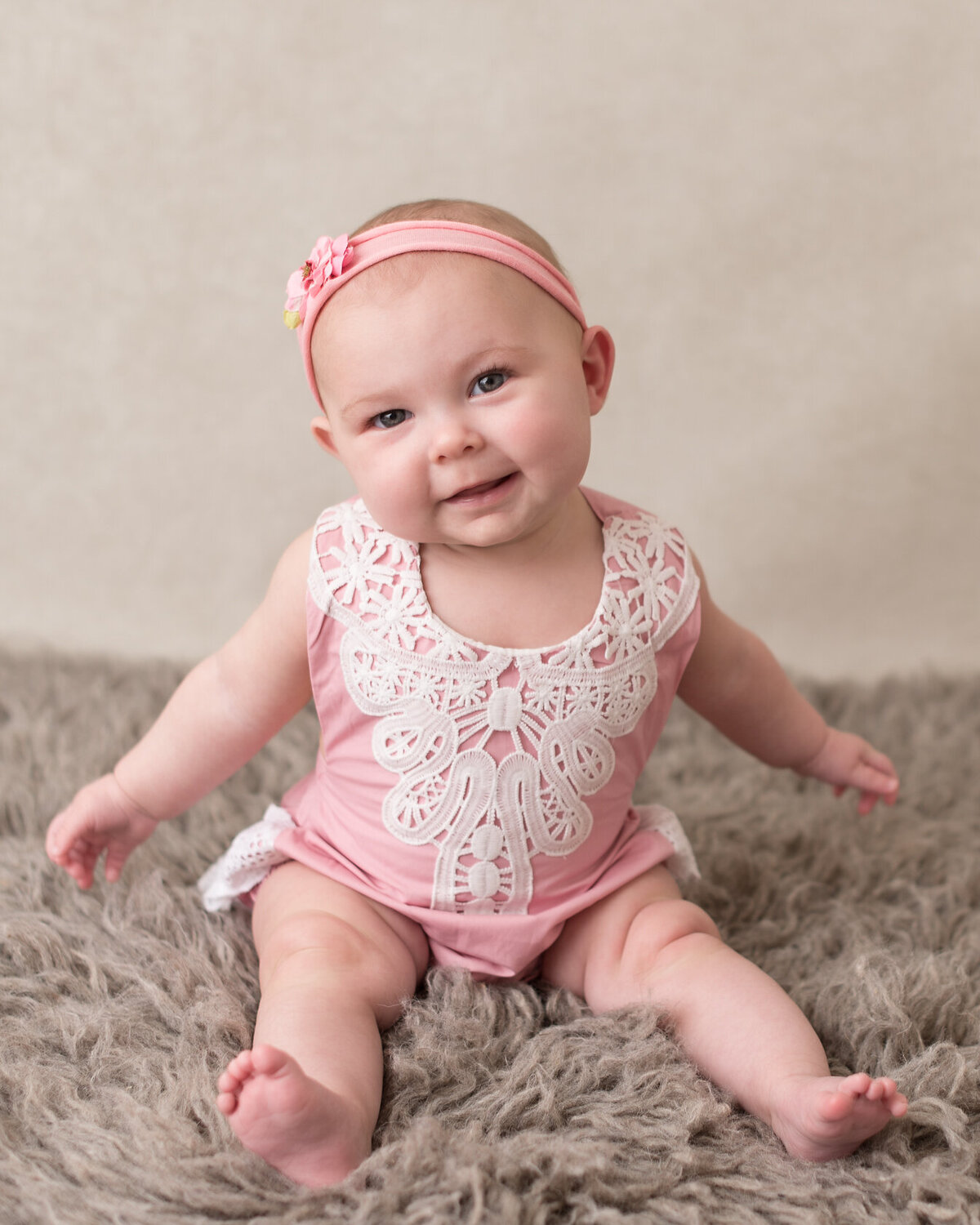 adorable baby in pink dress and brown furry background