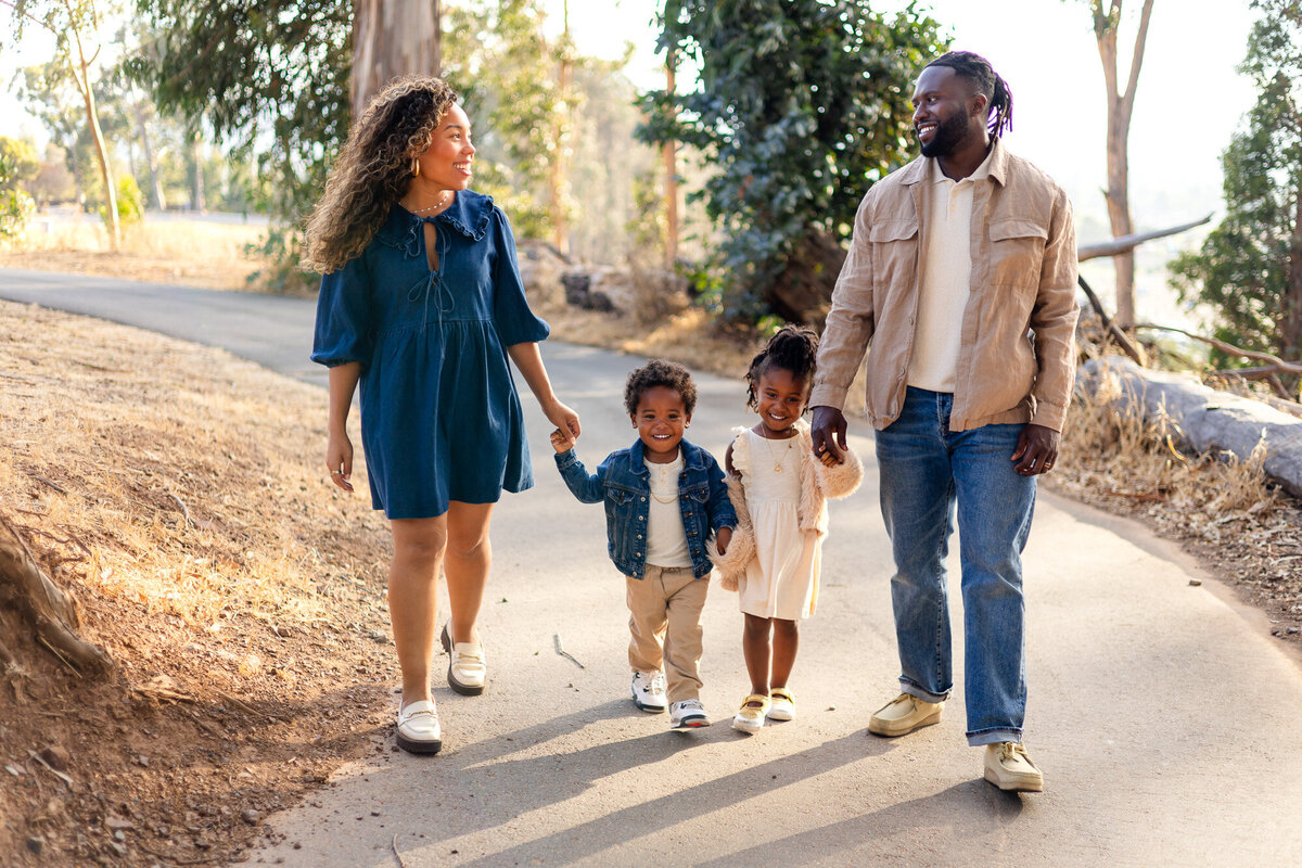 Family of four laughing holding hands walking in an outdoor family session, Bay Area Family Portfolio – Ellobelle Photography