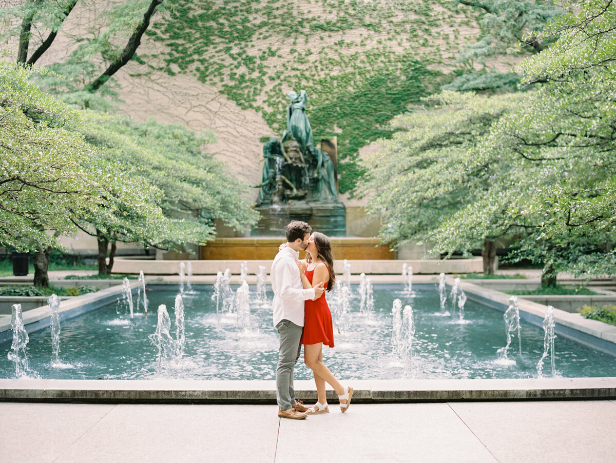 Bride and groom kissing in front of fountain photographed by Chicago editorial wedding photographer Arielle Peters