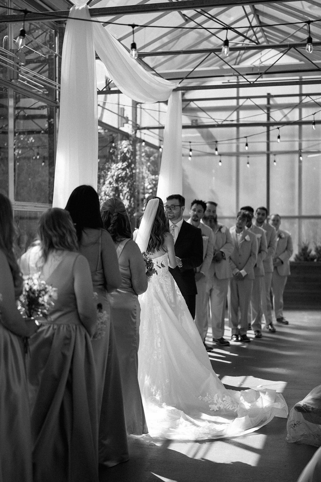 Black and white wide-angle photo showing the entire bridal party during the Ivy House wedding ceremony in Saugatuck, Michigan.