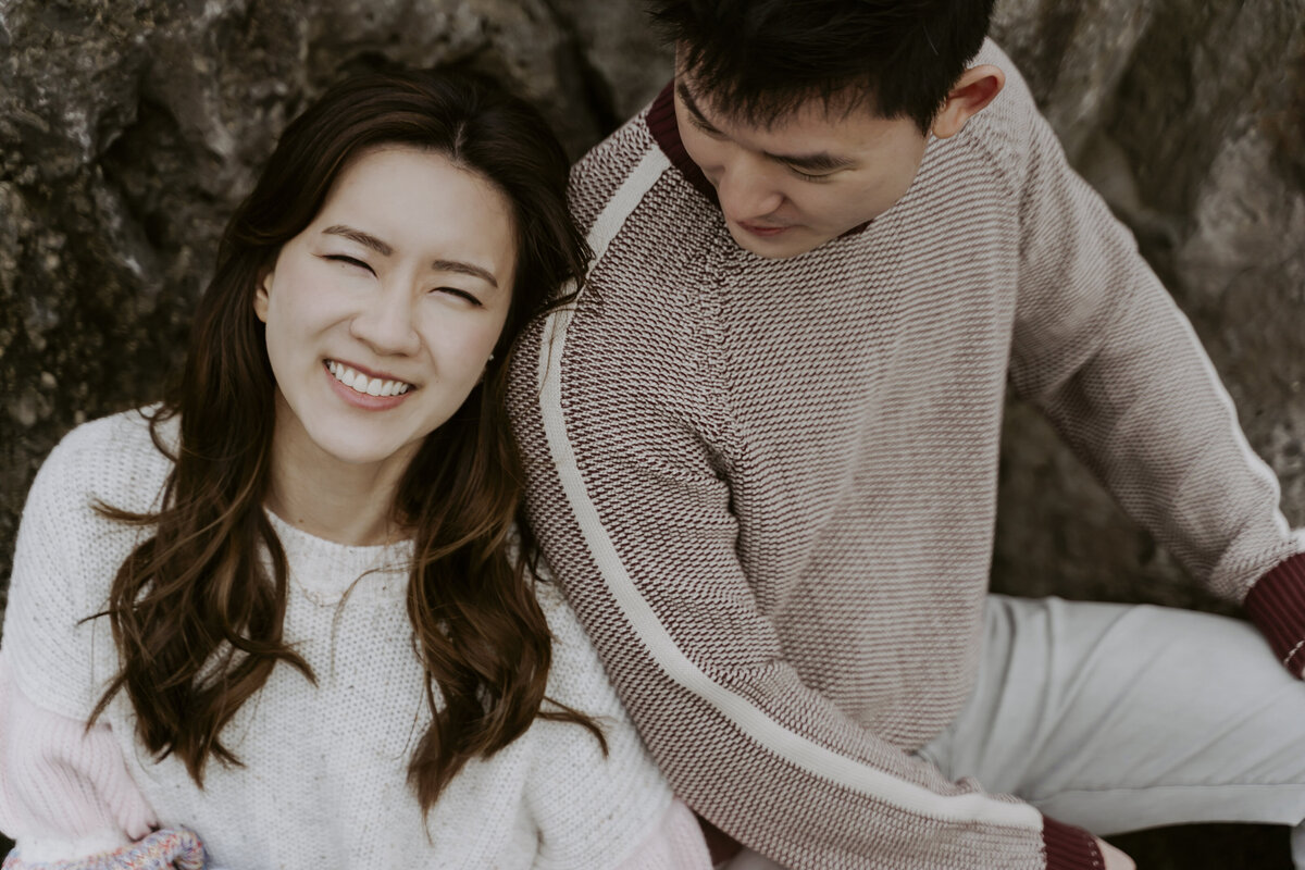 the bride smiling and leaning her head on the groom's shoulder and he is staring at her