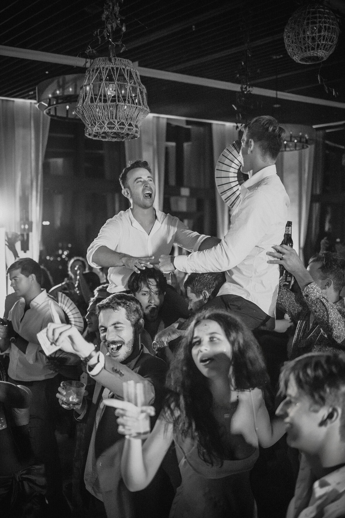 Two grooms dance a hora  at a destination wedding in Puerto Rico
