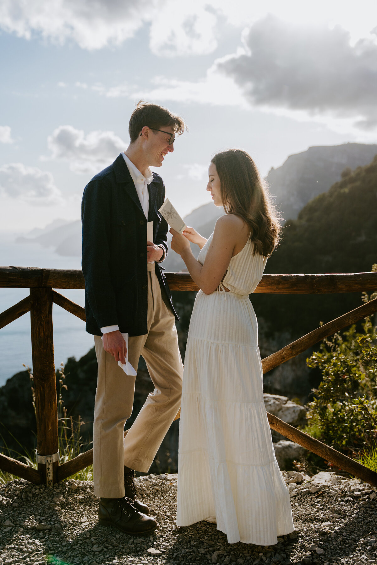 Couple reading vows at wooden railing.