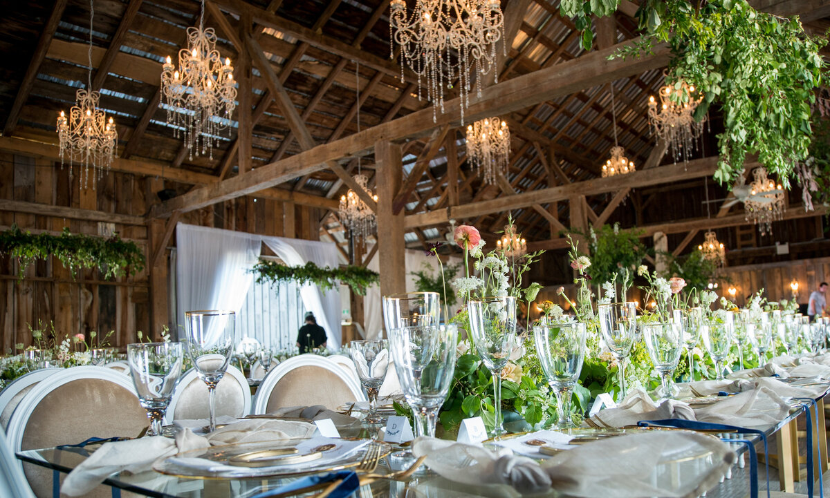 A wedding reception featuring lush greenery and floral centrepieces at the barn chic Evermore.
