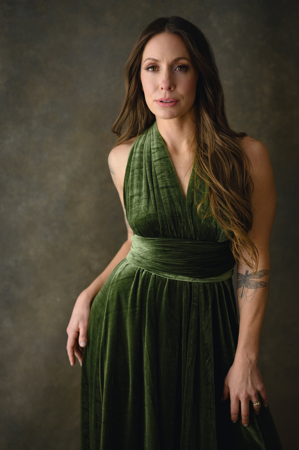 Portrait of a woman in a green velvet gown, radiating confidence and grace, captured by Leslie Q Photography