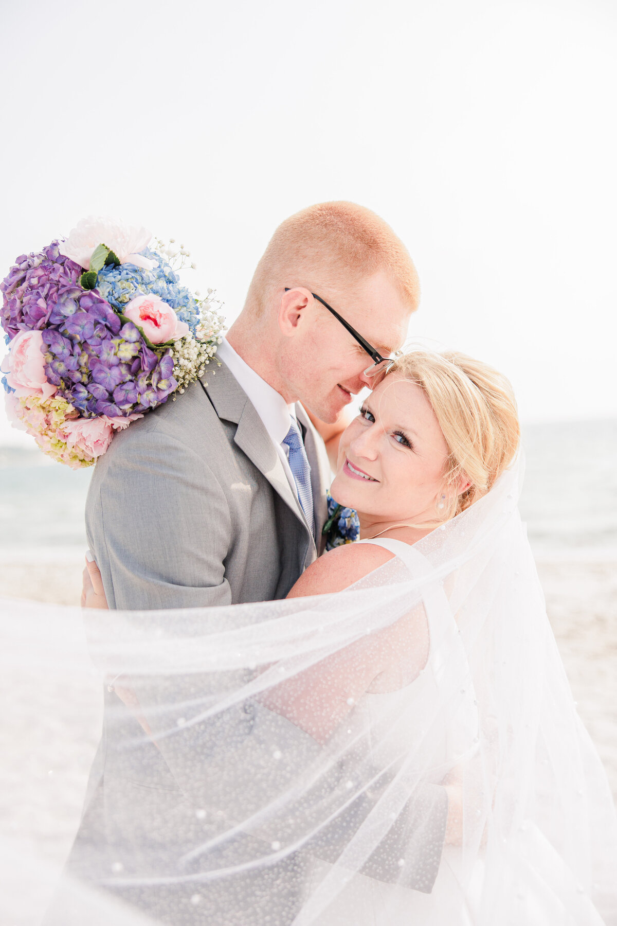 A groom snuggling with his bride representing romantic Cape Cod wedding photos