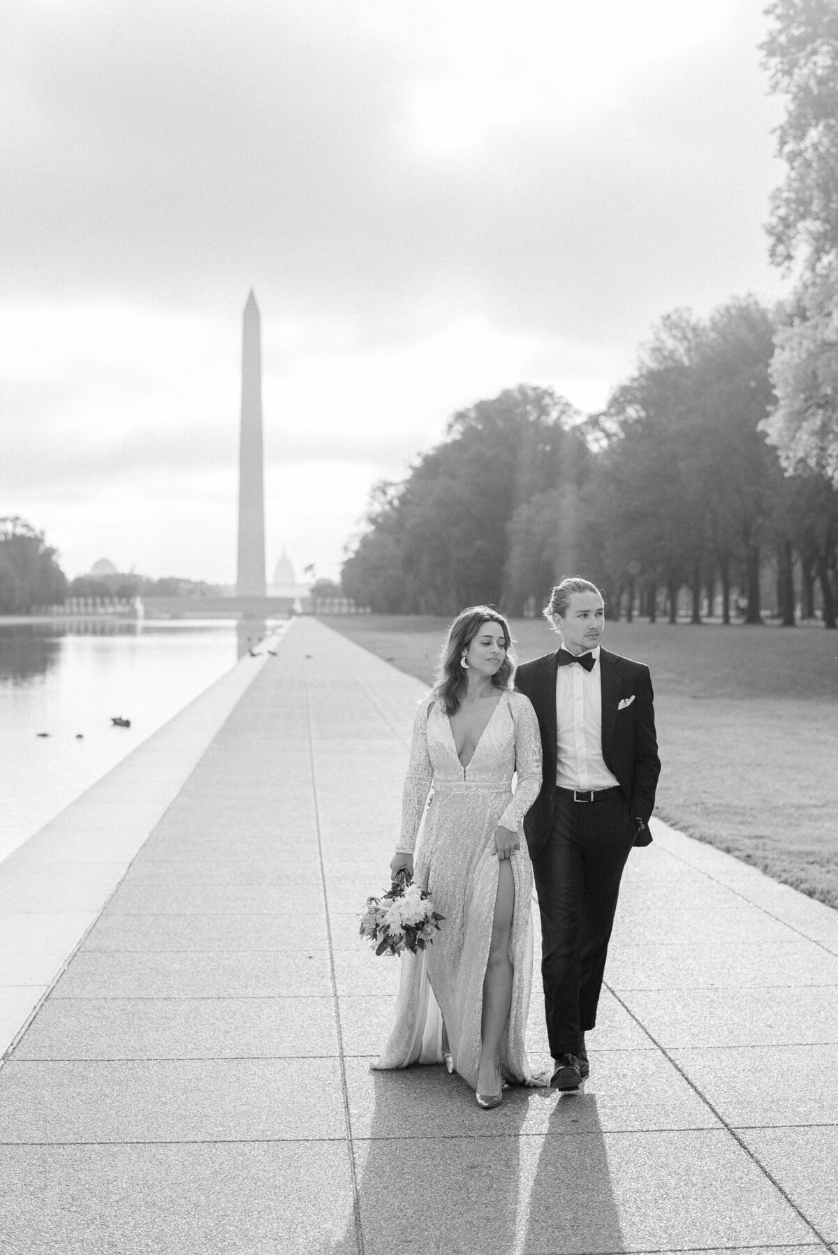 Bride and groom walking along the Lincoln memorial reflecting pool in wedding attire fine art wedding photography washingtin DC