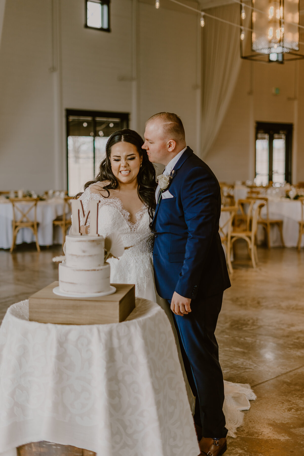 bride-groom-cutting-cake-des-moines-wedding-photographer-ashton-hill-farm-cedar-rapids-iowa-storyteller-collective-photo-co