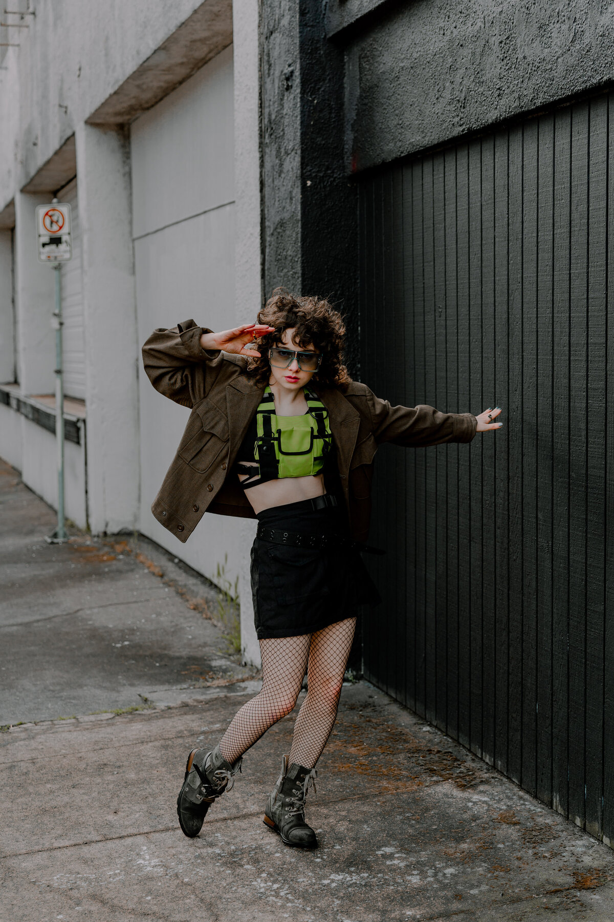 Bold fashion portrait of woman dancing near a white-and-black alleyway – edgy city branding by Mewphotovideo