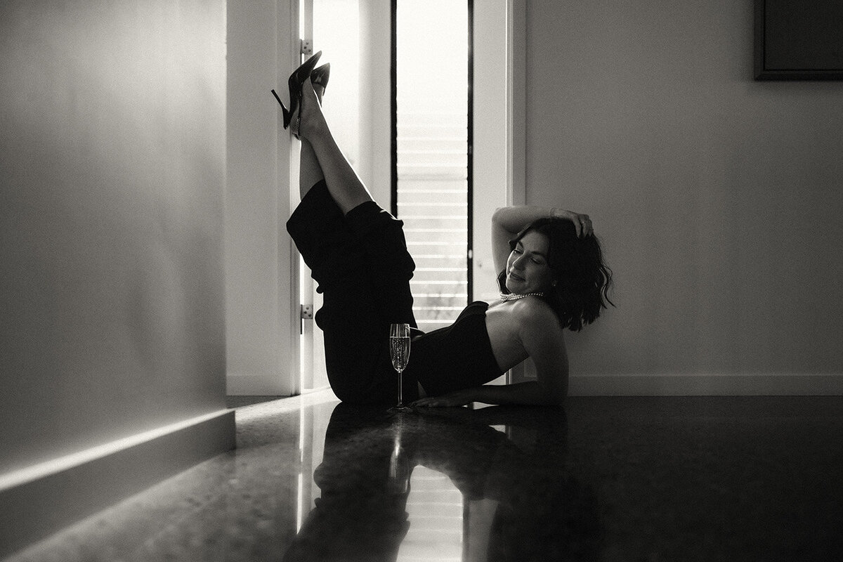 Sunshine Coast branding photographer documents grounded strength in this soft black-and-white floor stretch pose.