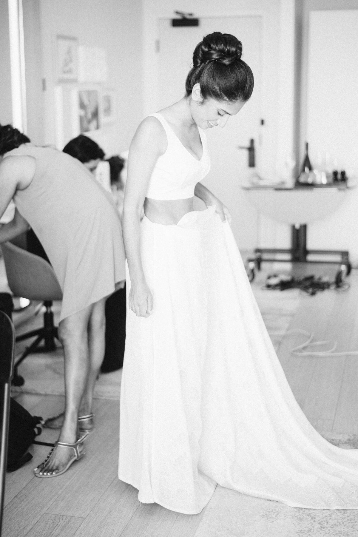 Bride taking a look at her dress in a black and white photo