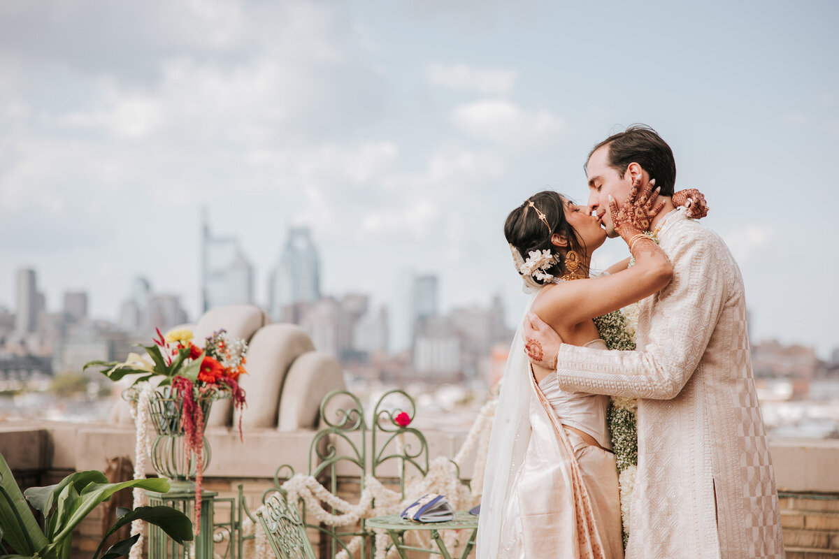 Joyful bride and groom celebrating at their wedding reception with floral decorations and warm lighting in Philadelphia.