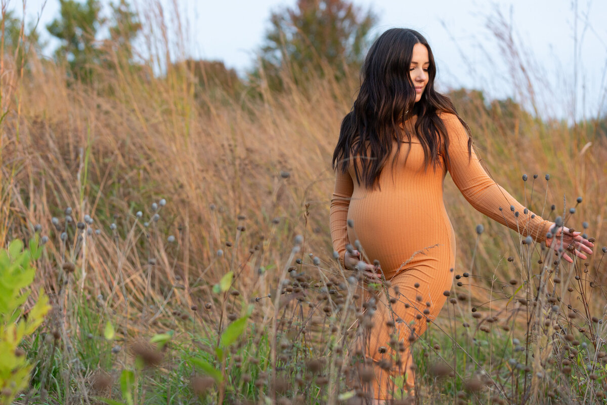 Expecting mother in orange dress in field at sunset - Jen Madigan - Naperville IL maternity photographer