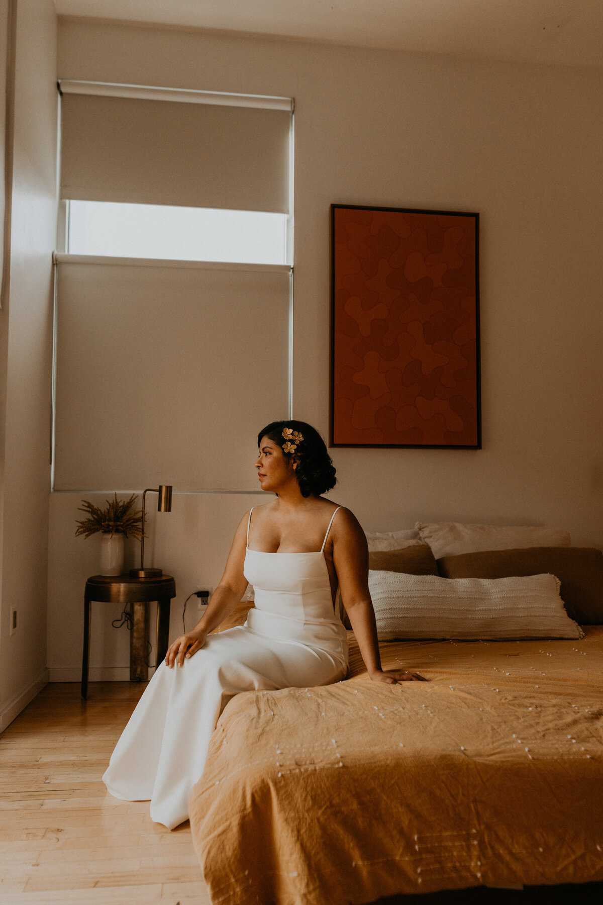 bride and groom sitting on  a bed together before their ceremony