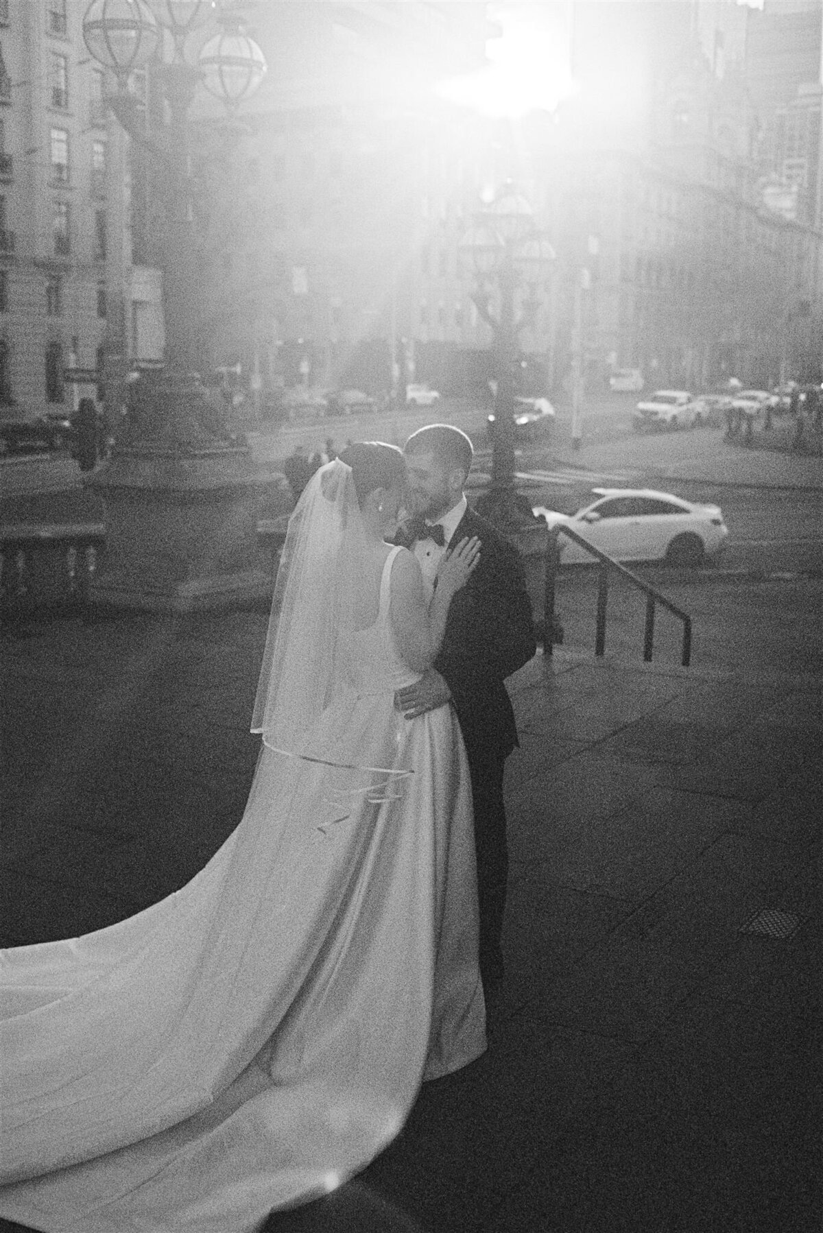 Couple sharing a sweet, candid moment outside the registry office, captured authentically on 35mm film.