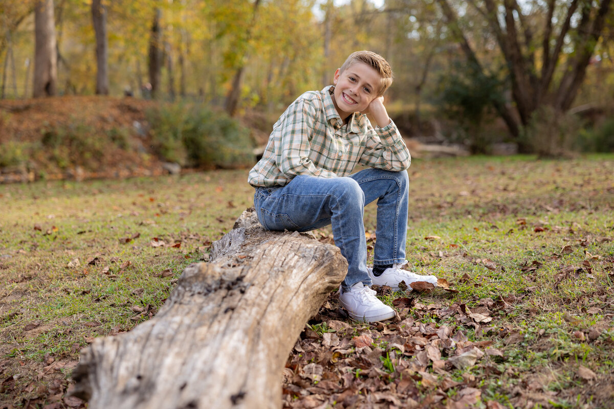 a boy sitting on a log