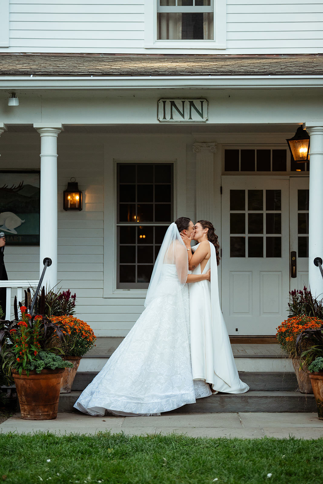 Brides kissing under The White Hart Inn sign