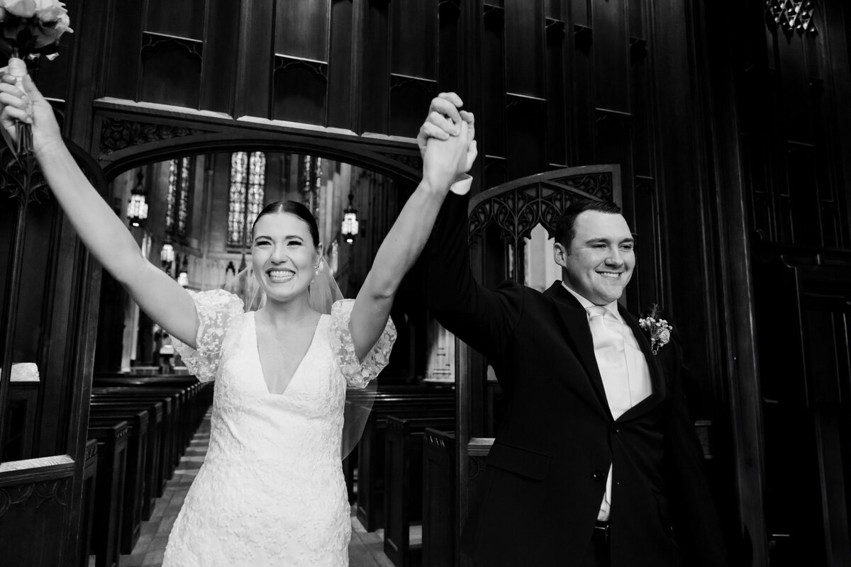 Bride and groom hold hands as they are welcomed by family and friends as they exit Heinz Chapel on their wedding day. Photo taken by Aaron Aldhizer