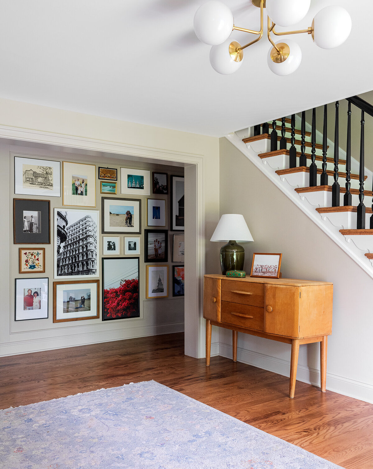 foyer to hallway photo wall with staircase and storage cabinet