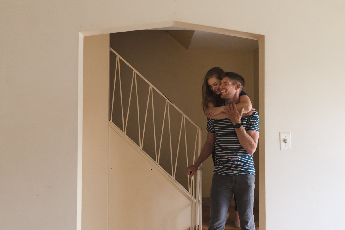 Couple cuddling on the staircase of their new home