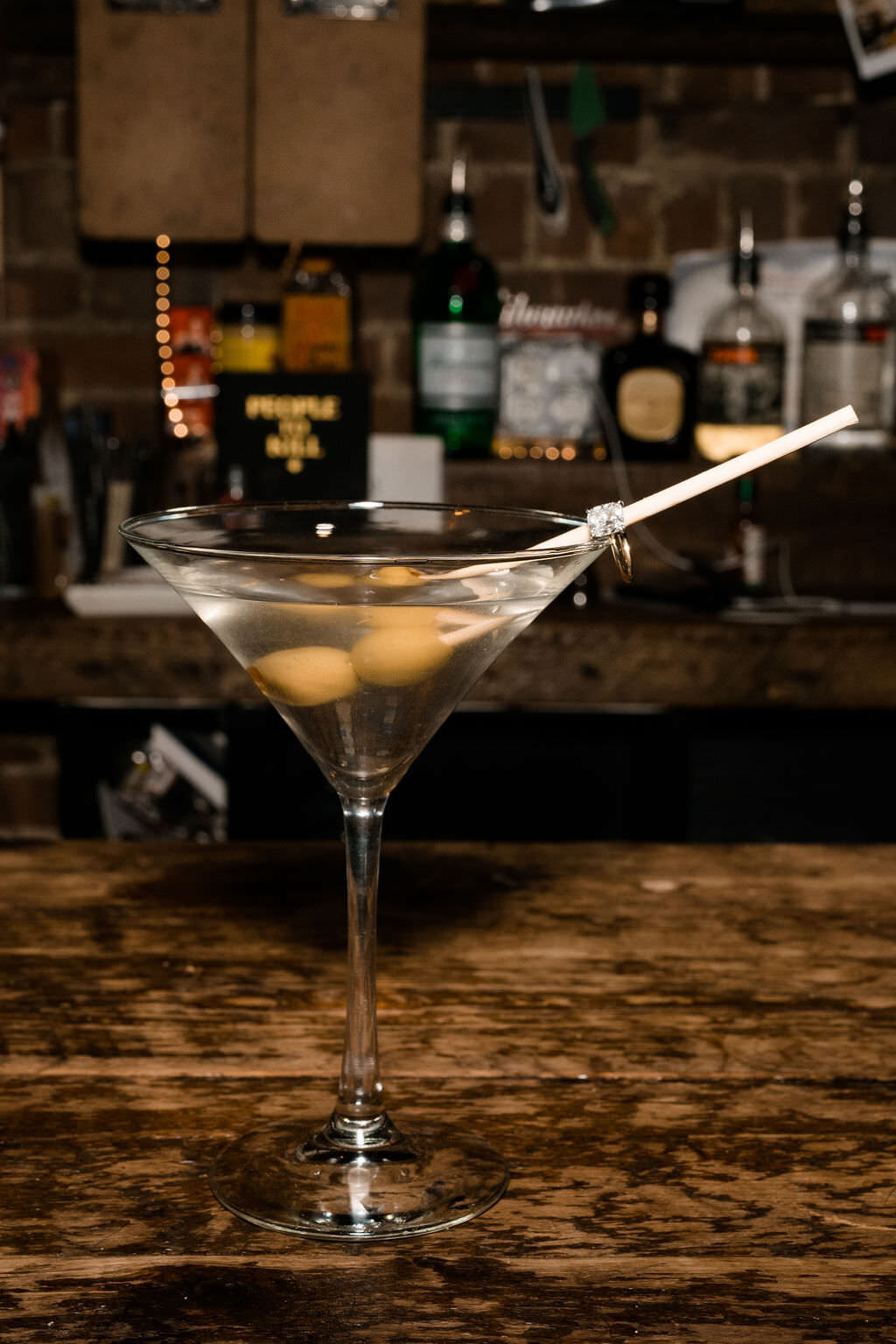 martini with olives sitting on a bar