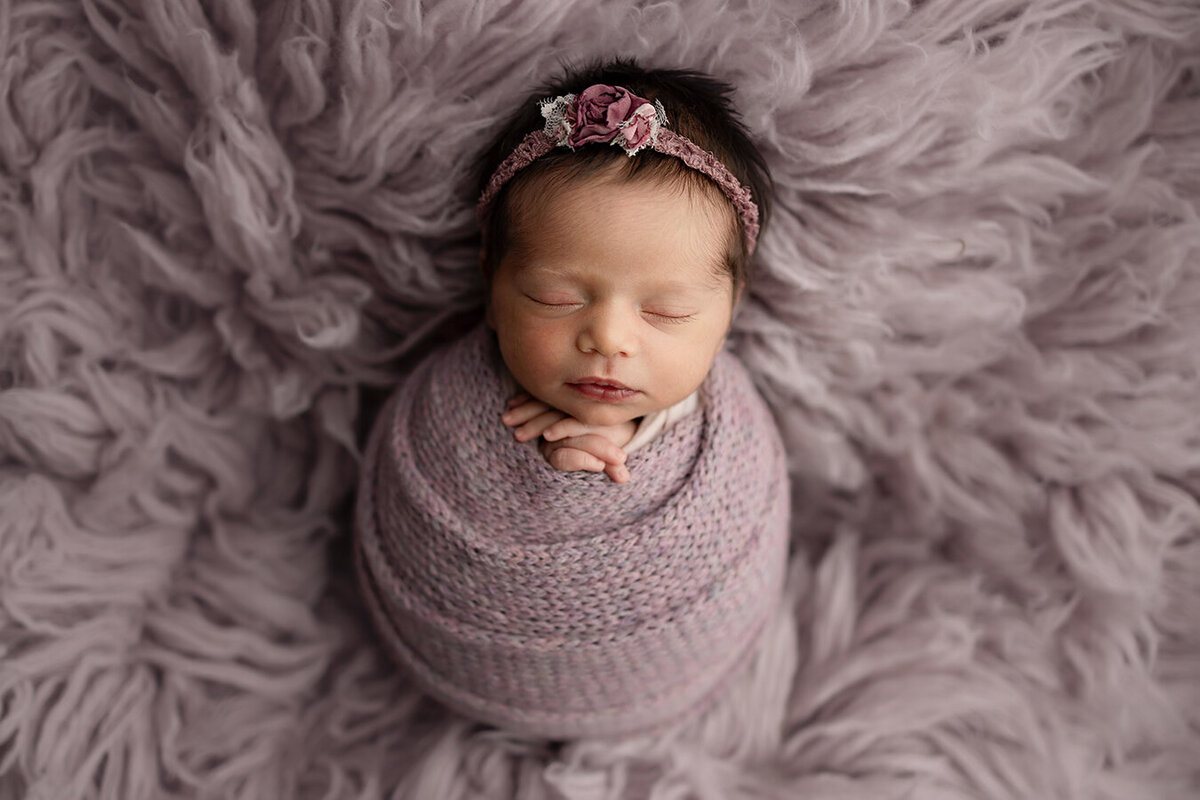 Fort Collins Colorado baby wrapped in purple laying on a rug