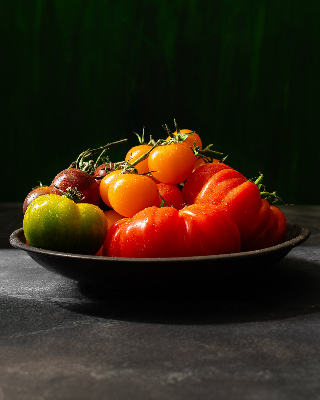 Mixed Tomatoes in a rustic bowl on a stone worktop