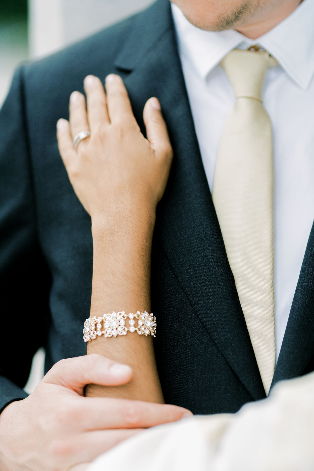 bride puts hands up on her groom as the groom hold her arm