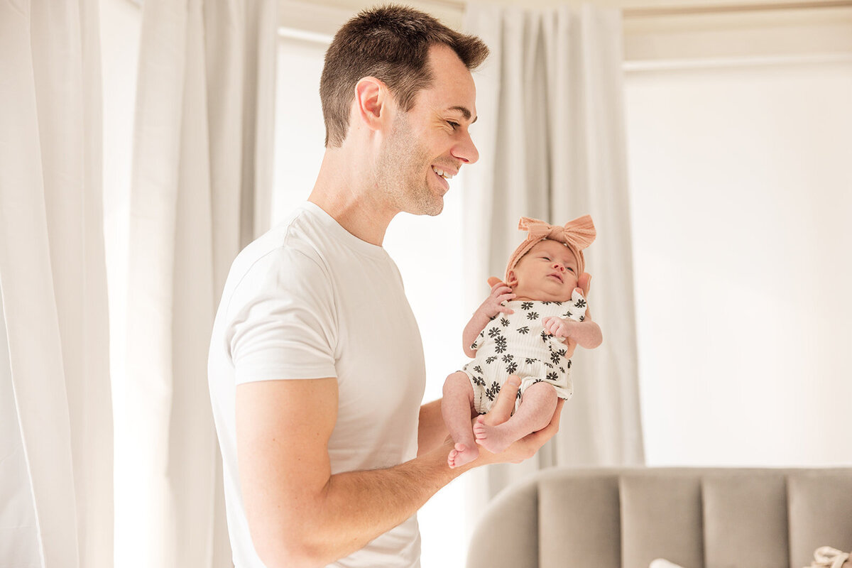 Father snuggling baby girl during relaxed in-home photo shoot in Orlando

