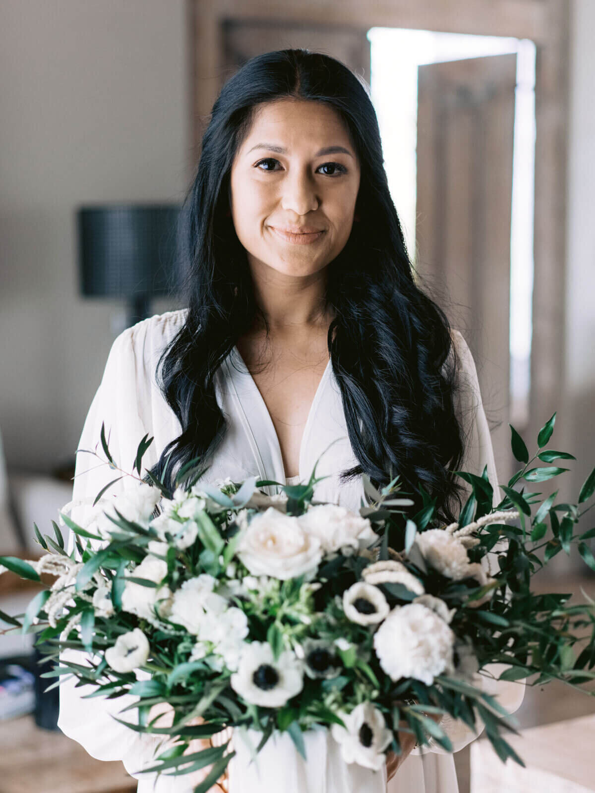 The bride is holding her flower bouquet inside the room before the wedding in Khayangan Estate, Indonesia. Image by Jenny Fu Studio