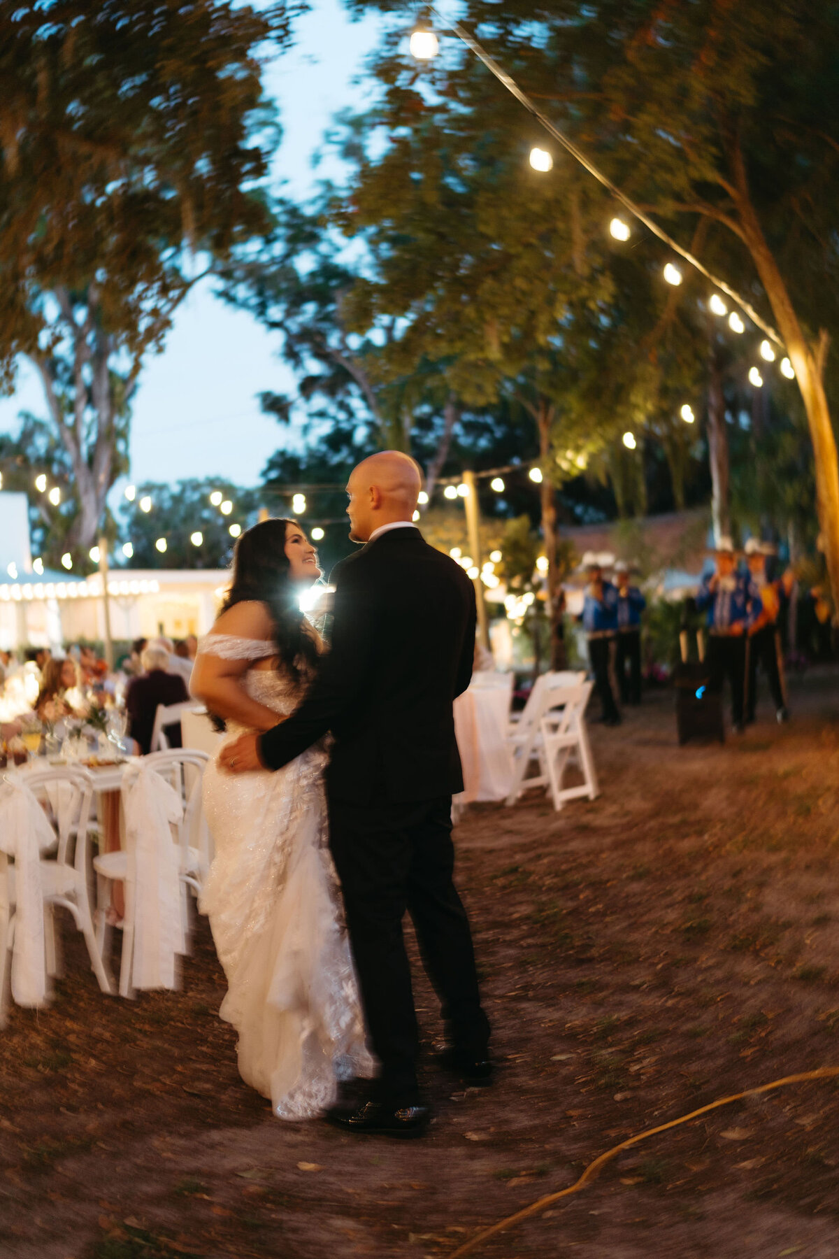 Newlyweds share a romantic first dance under twinkle lights at Uliana Estate, a dreamy Lakeland FL wedding venue.