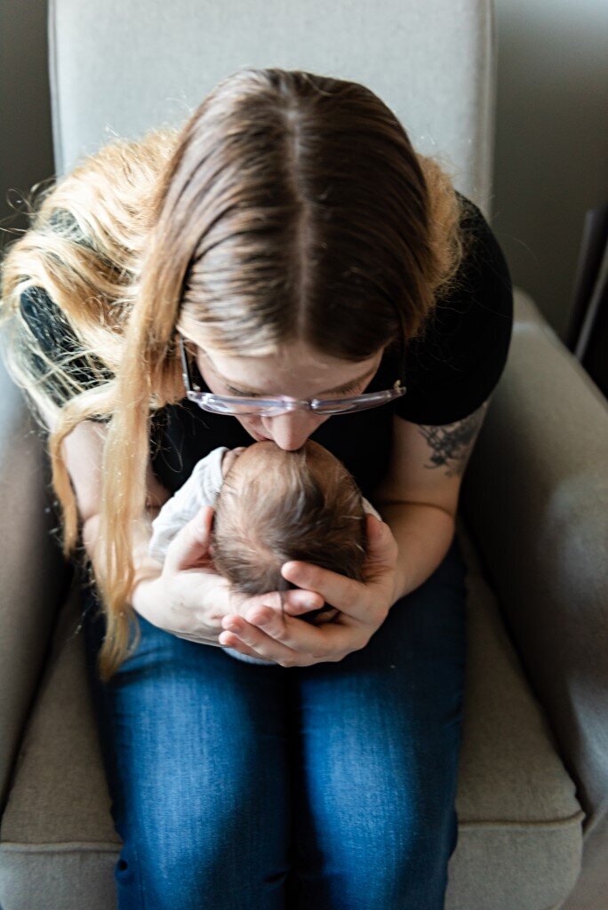 mom sitting holding newborn boy